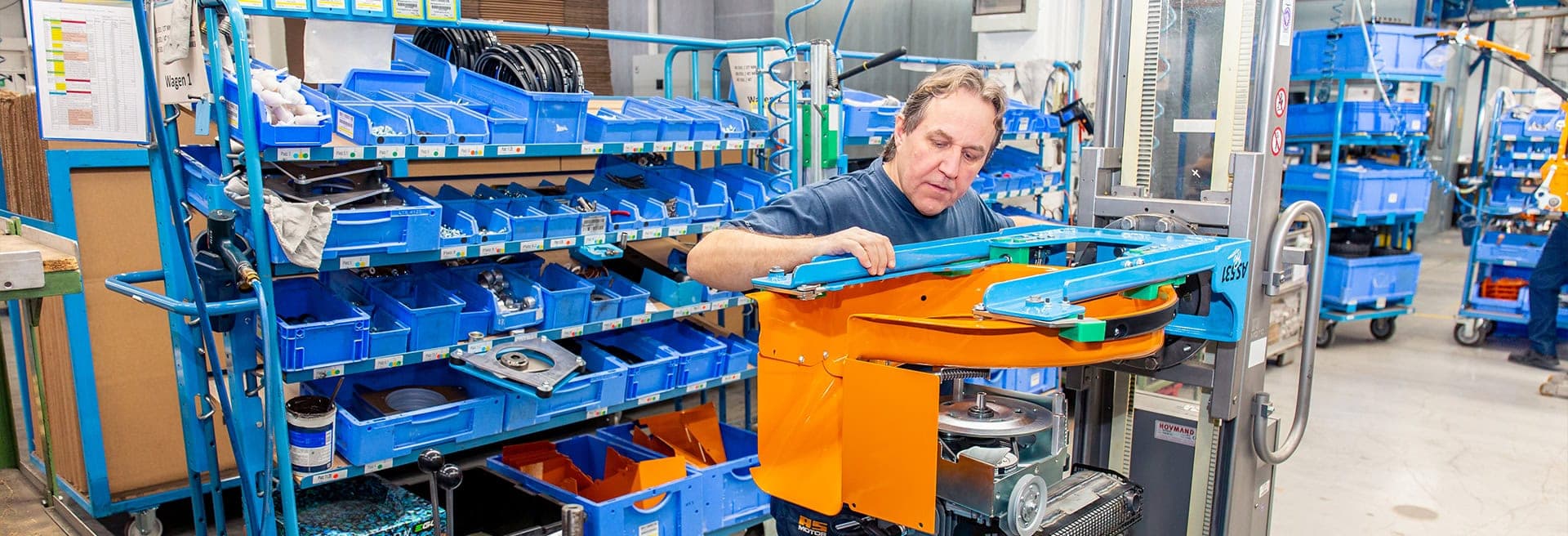 AS-Motor warranty highlight, showcasing the craftsmanship inside the AS-Motor factory. A man is torquing down the main bolt for the mower blade