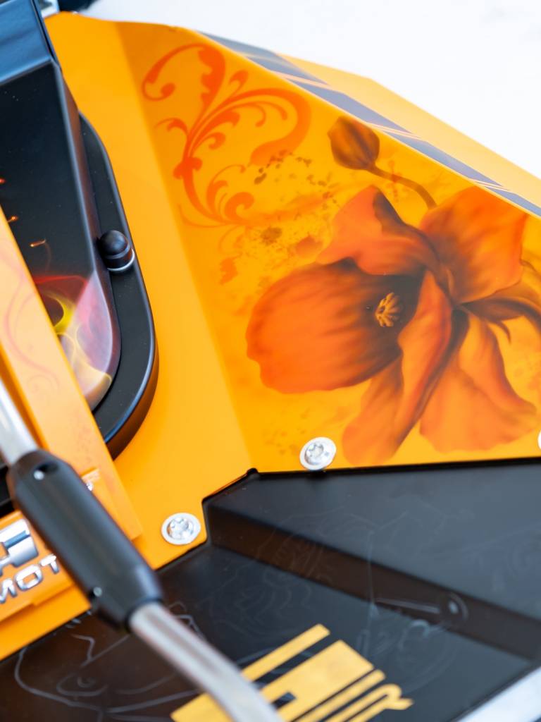 Florales Airbrush-Motiv auf der orangefarbenen Verkleidung des AS 63 Allmähers